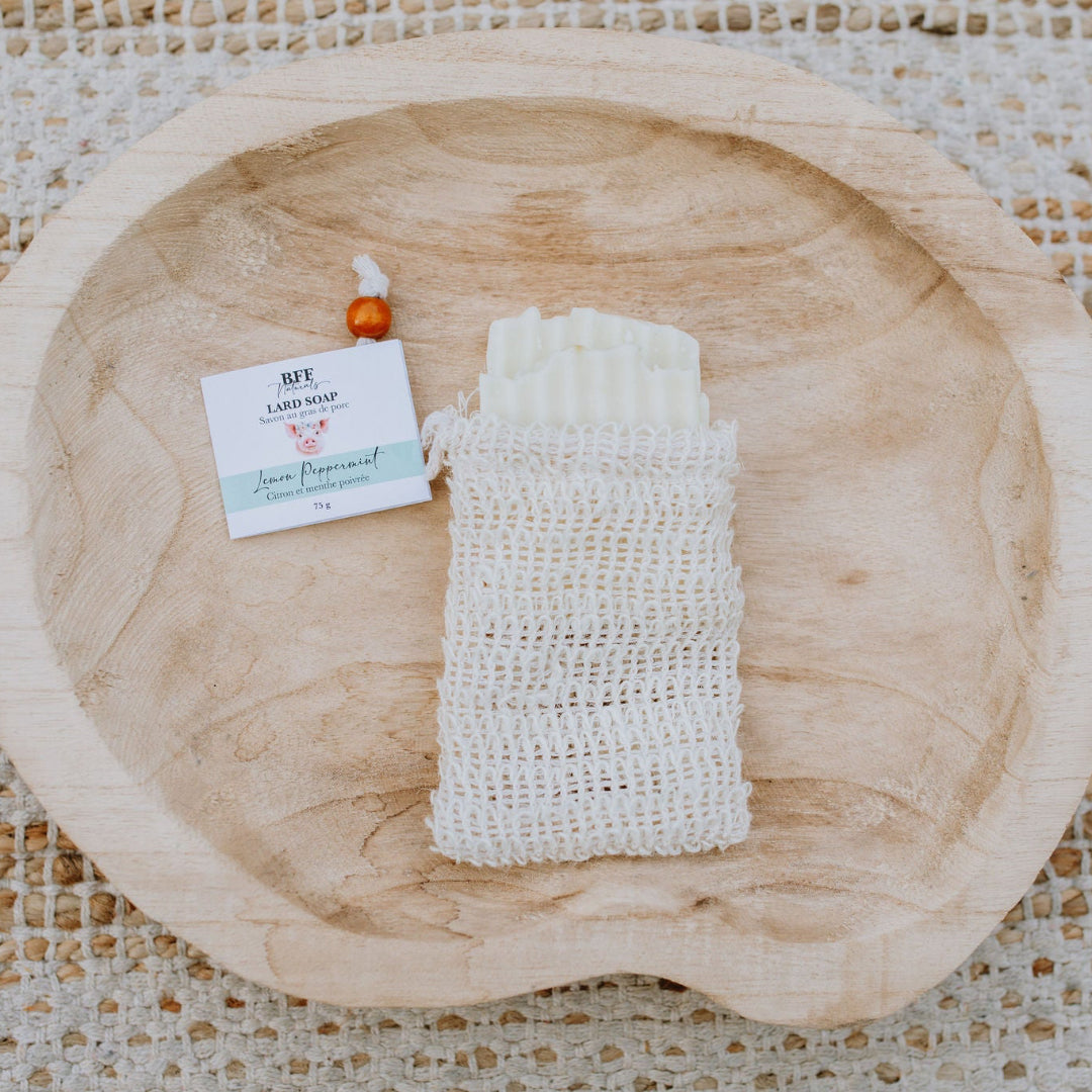 BFF Naturals Farmhouse Soap in Lemon Peppermint scent, shown in a natural loofah bag on a wooden bowl.